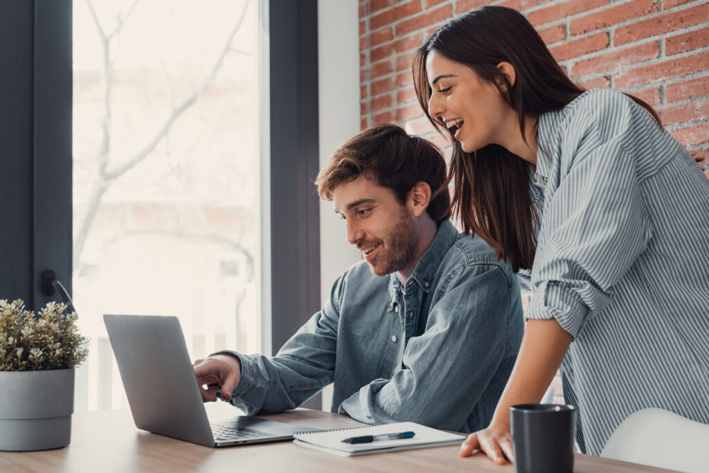 Pareja joven revisando información sobre subsidios habitacionales desde su laptop