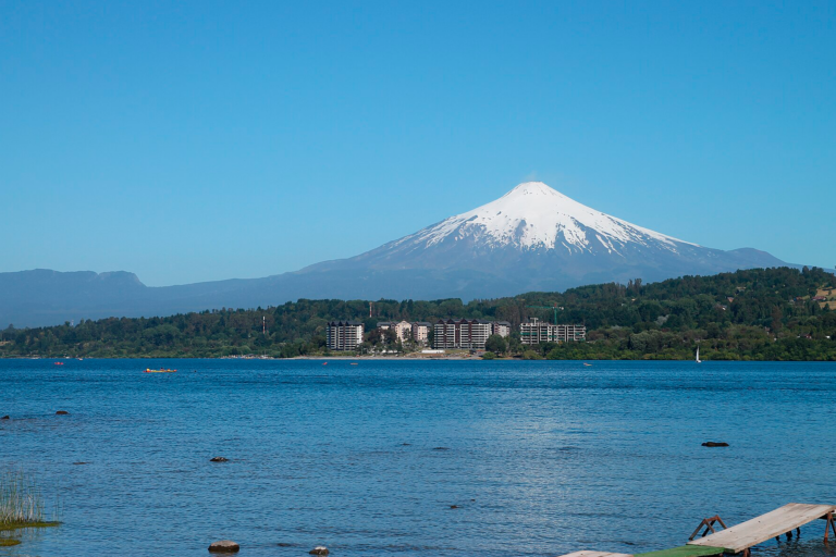 Vista del lago Villarrica con el volcán nevado al fondo y proyectos inmobiliarios en primera línea